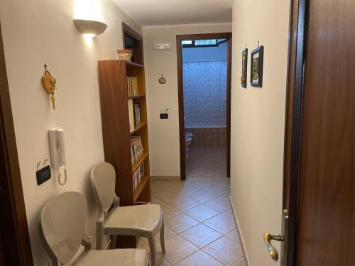 a bathroom with two chairs and a toilet in a room at Sea Living Sicilia Apartment in Santa Flavia