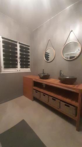 a bathroom with two sinks and two mirrors at La closerie aux écureuils in Limeux