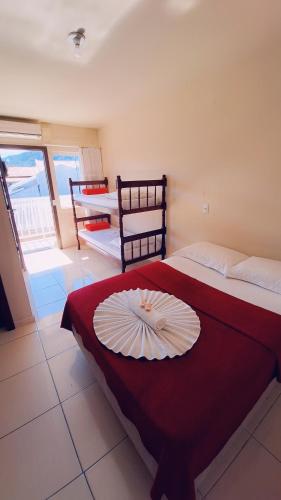 a room with a bed with a plate on it at Pousada Parque Central in Penha