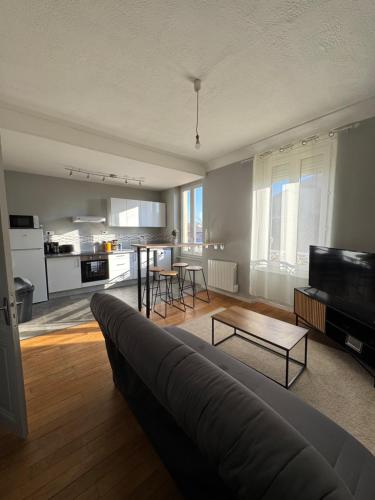 un salon avec un canapé et une table et une cuisine dans l'établissement Centre ville - Proche cité médiévale, à Carcassonne