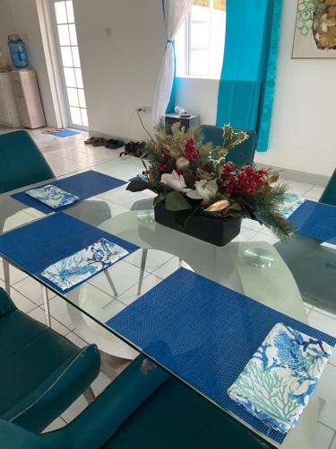 a glass table with a vase of flowers on it at Seabliss Villa in Vieux Fort