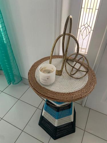 a rattan table with a cup on top of it at Seabliss Villa in Vieux Fort