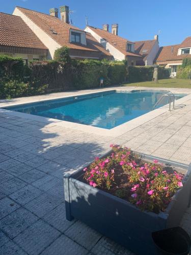 a large swimming pool with flowers in a planter at Chalet Monte da Garda in O Grove