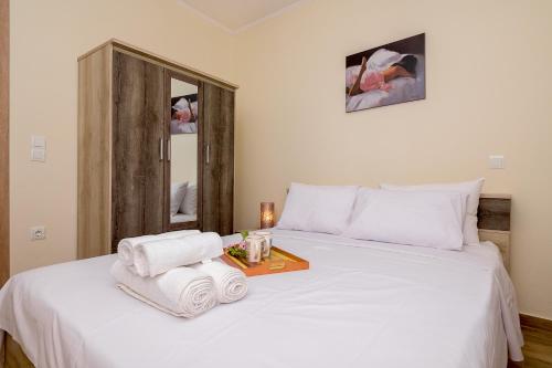 a bedroom with a bed with towels and a mirror at OliveHousesAXD in Mákri