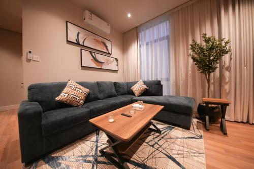 a living room with a black couch and a table at Nma a Residences 2 in Riyadh