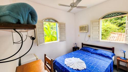 a bedroom with a bed and two windows at BUONA SORTE in Lençóis