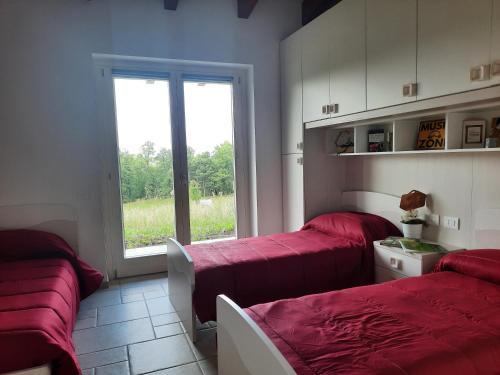 two beds in a room with a window at VILLA MILLEFIORI in Tornareccio