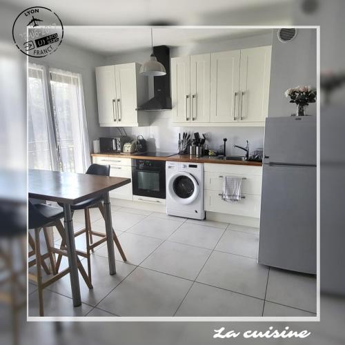 une cuisine avec une table et un réfrigérateur blanc dans l'établissement Appartement Tassin Centre - 15' de Lyon - 1 Parking, à Tassin-la-Demi-Lune