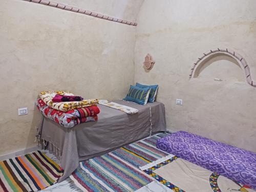 a bedroom with a bed and a rug at Maisons la Porte de Désert à Douz in Douz