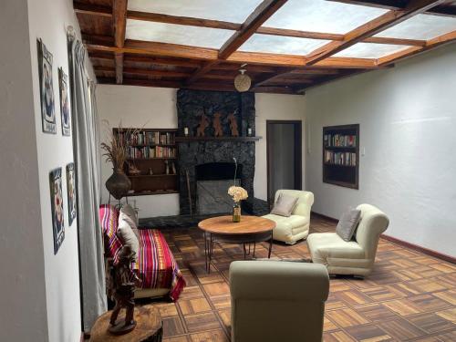 a living room with a table and chairs and a fireplace at Granja Picalquí in Tabacundo