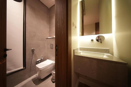a bathroom with a sink and a toilet and a mirror at Nma a Residences 2 in Riyadh