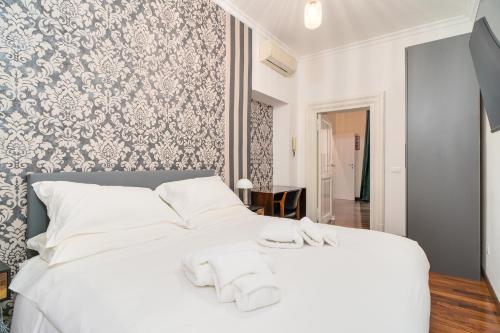 um quarto com uma cama branca com toalhas brancas em OLEUM Roma Veneto em Roma