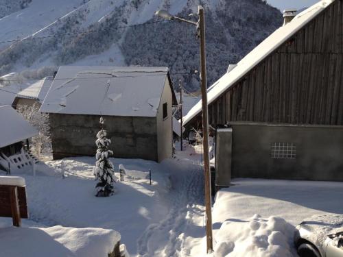 a building with snow on the ground next to a pole at Le Chalet des Séraphins in Saint-Sorlin-dʼArves