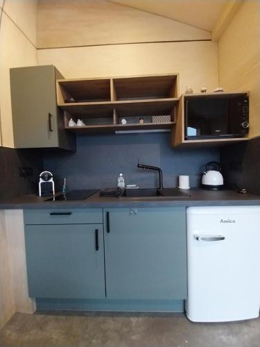 a kitchen with a sink and a microwave at Chalet Le Côme in Mazaye