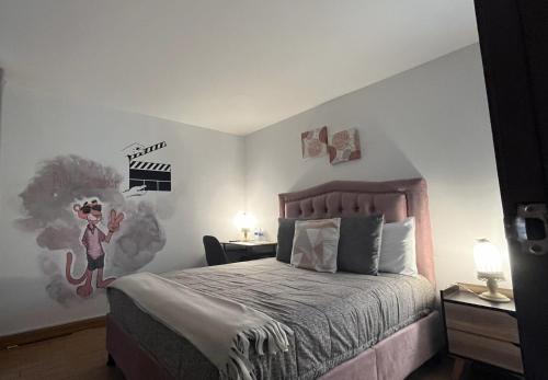 a bedroom with a bed with a hello kitty painting on the wall at HOSTAL SEP7IMO ARTE in Bogotá