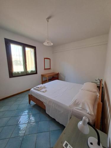 Un dormitorio con una cama y una ventana y una mesa. en Casa Tonnarella San Vito Lo Capo, en San Vito lo Capo