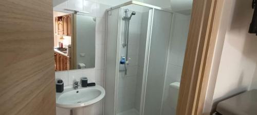 a white bathroom with a shower and a sink at Casa il cortile in San Cataldo