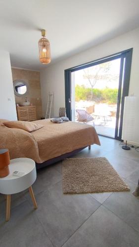 - une chambre avec un grand lit et une grande porte coulissante en verre dans l'établissement Villa Isula Contemporaine, à Palasca