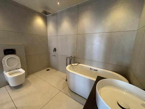 a bathroom with a tub and a toilet and a sink at Baga Beach Sea Salacia in Goa