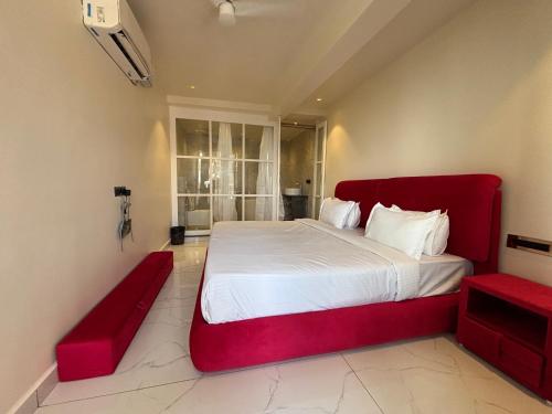 a bedroom with a red bed and a red bench at Baga Beach Sea Salacia in Goa
