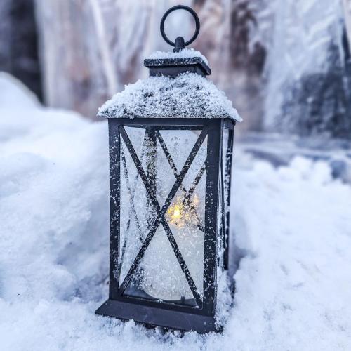 a lantern covered in snow in the snow at SKOG - Aurora Igloos Resort in Kalix