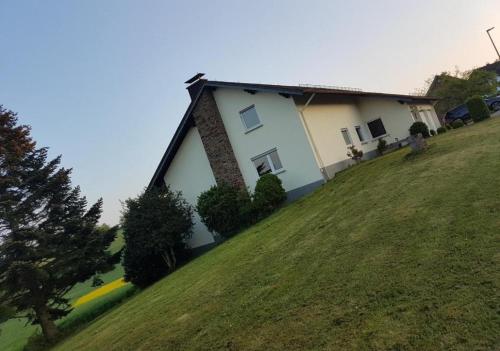 a house on top of a grassy hill at Ferienwohnung zur Falkenlay Bad Bertrich in Bad Bertrich