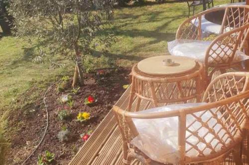 a deck with two chairs and a table in a garden at Magnifique chalet au calme total in Réau
