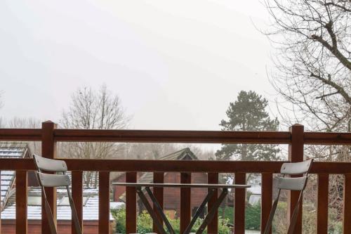 two chairs and a table on a wooden fence at Magnifique chalet au calme total in Réau