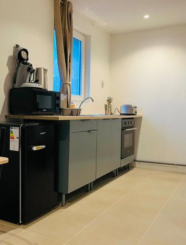 a kitchen with a sink and a counter top at Le milazo au cœur de la campagne in Touffreville