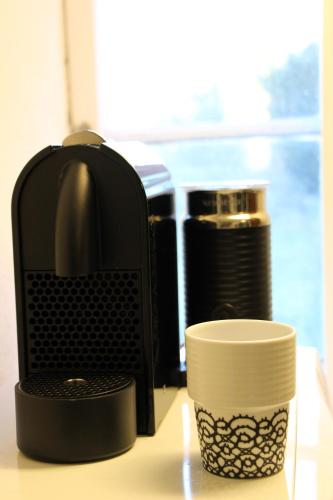 a coffee maker and a cup on a table at Solbacken in Bjärred