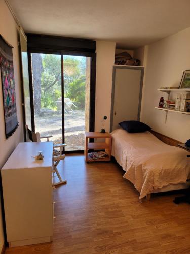 une chambre avec un lit, un bureau et une fenêtre dans l'établissement Charming house in private estate, à Bormes-les-Mimosas