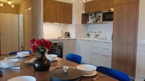 une cuisine avec une table avec un vase de fleurs dessus dans l'établissement Dream Suite Deluxe, à Chessy