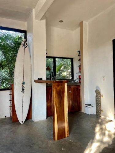 a surfboard leaning against a wall in a room at La Punta SurfHouse AC Starlink in Brisas de Zicatela