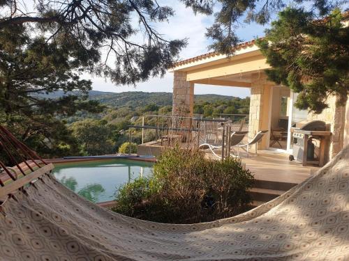 - un hamac en face d'une maison avec piscine dans l'établissement Villa bord de mer, à Sartène