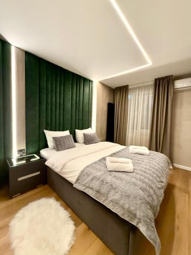 a bedroom with a bed with two towels on it at Jacuzzi Old Town Escape in Bucharest