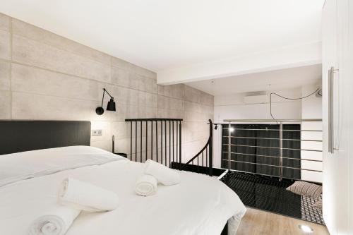 une chambre avec un grand lit blanc avec des draps blancs dans l'établissement Loft Industriel avec Terrasse et Filet Suspendu à Nice Cimiez, à Nice