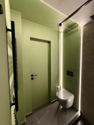 a bathroom with a toilet and a glass door at Jacuzzi Old Town Escape in Bucharest