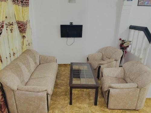 a living room with two chairs and a coffee table at Fantasia Residence in Wattala