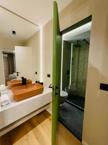 a bathroom with a orange sink and a shower at Jacuzzi Old Town Escape in Bucharest