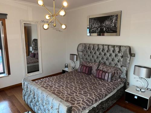 a bedroom with a large bed with a large headboard at Luxury Apartment near Beach & Golf in Amora