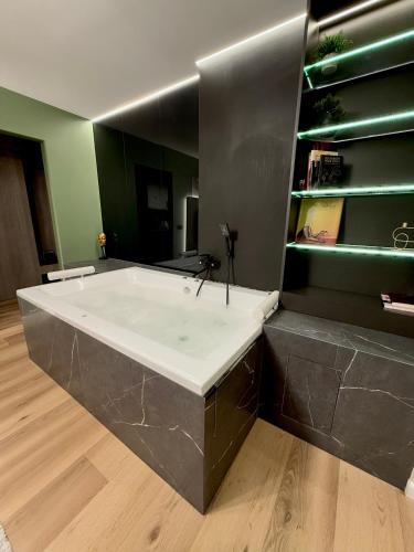a large bath tub in a room with a wooden floor at Jacuzzi Old Town Escape in Bucharest