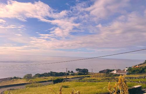 a view of the ocean from a hill with the sky at Casa do Grotão - Turismo no Espaço Rural - Alojamento Rural in Ribeiras