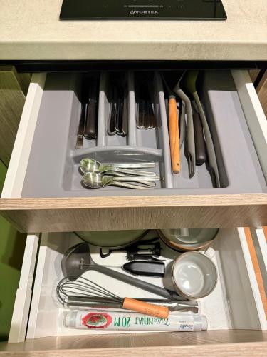 a drawer filled with cooking utensils in a cabinet at Jacuzzi Old Town Escape in Bucharest