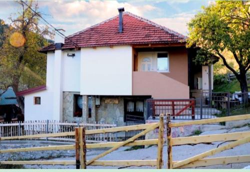 a house with a fence in front of it at Malo selo Kurikuce in Berane
