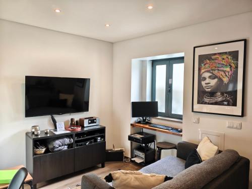 een woonkamer met een bank en een flatscreen-tv bij The Old Town House by Freetimealgarve in Faro