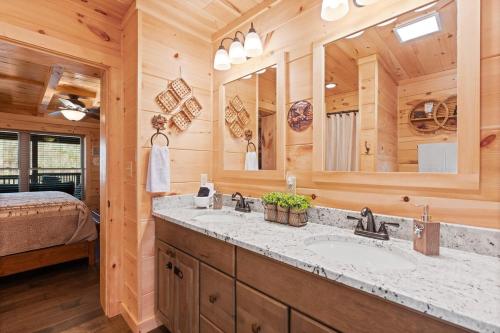 a bathroom with a sink and a large mirror at Woodlake Log Cabin in Elk Park