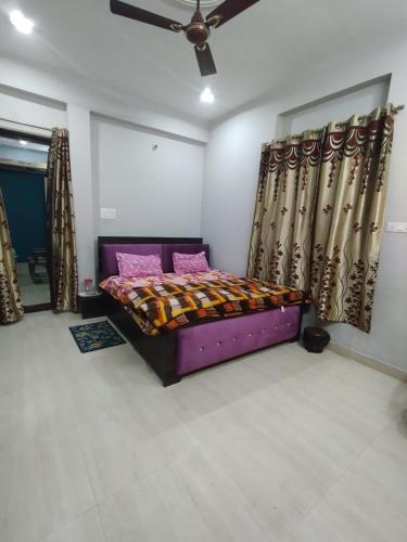 una camera con letto e tende viola di The Family Nest a Prayagraj