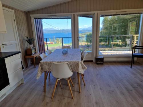 a dining room with a table and a view of the ocean at Cabin with lovely view in Lakså