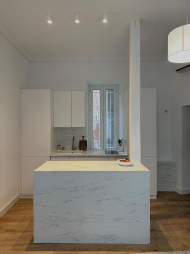 - une cuisine avec un îlot blanc dans une chambre dans l'établissement Appartement Nemausus XIX, à Nîmes