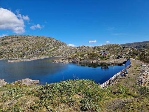 a lake with a house on the side of a hill at Cabin with lovely view in Lakså